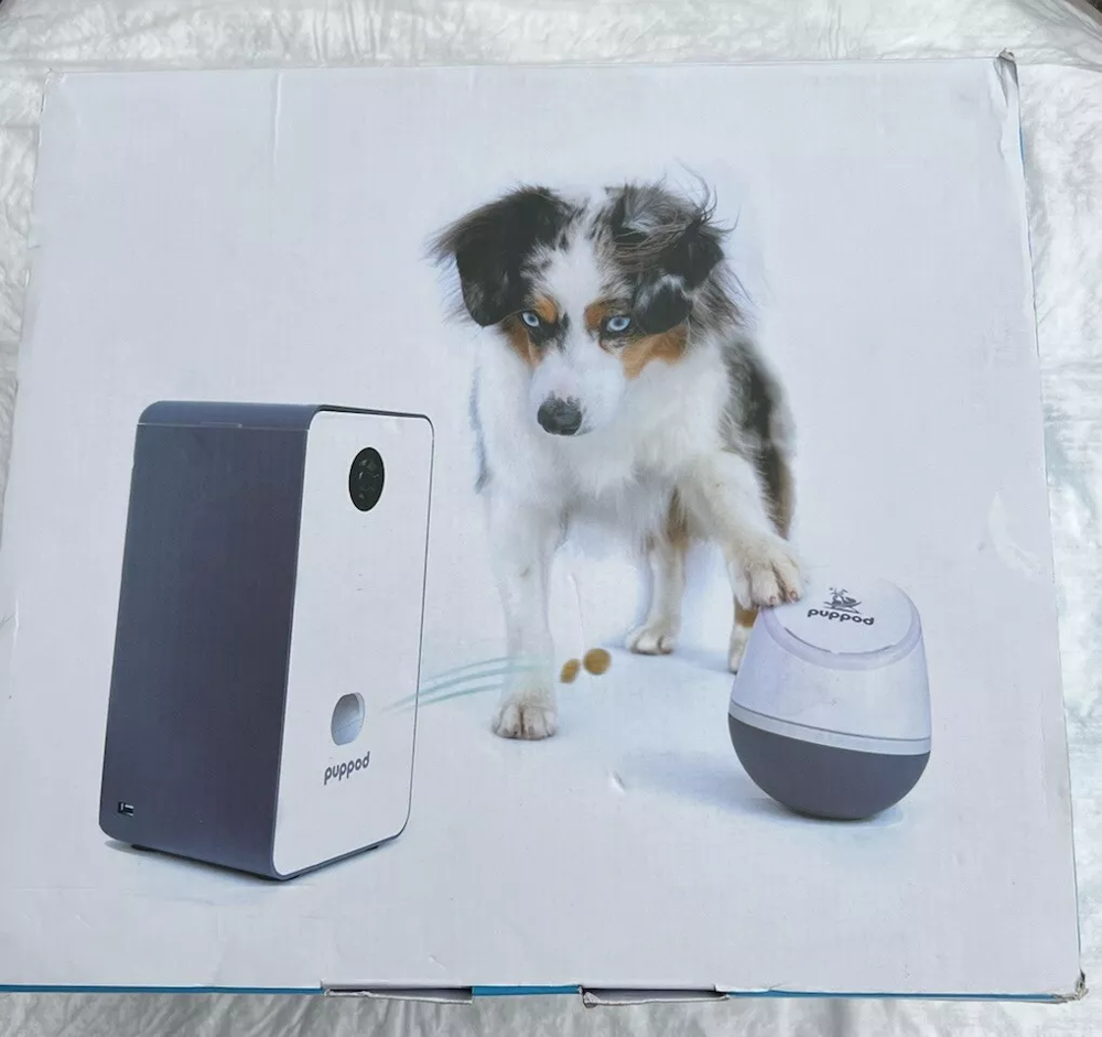The PupPod bundle turns training time into an arcade game. Dogs tap a Bluetooth-enabled “Rocker” toy. Then they watch treats shoot from a feeder tower. You observe this on the built-in camera. 